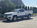 A 2017 Chevrolet Colorado in white with blue accents featuring a utility box mounted in the truck bed and front grille guard