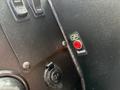 Close-up of the dashboard controls in a 2020 Freightliner MT45 featuring a red event button and a key ignition socket