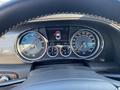 A close-up view of the dashboard of a 2015 Bentley Continental GT showing speedometer tachometer and fuel gauges