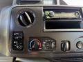 Dashboard controls of a 2015 Ford Econoline showing climate control knobs and a car stereo system