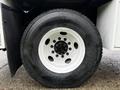 Close-up of a 2020 International MV607 truck tire featuring a white rim with black lug nuts and a treaded surface