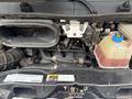 Engine compartment of a 2020 RAM Promaster showing various components including hoses a fluid reservoir and the engine block
