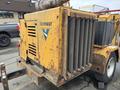 A 2015 Vermeer Corporation BC1200XL wood chipper featuring a yellow exterior with visible wear and a large grille for chipping wood materials