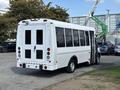A white 2018 Ford Transit-350 van with large windows and a rear door is parked with its side door open