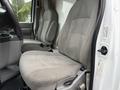 Interior of a 2013 Ford Econoline showcasing two gray cloth front seats with seatbelts and a central console