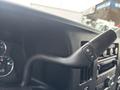 Close-up of a 2022 GMC Savana dashboard with a gearshift lever featuring a plus and minus sign for gear selection
