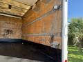 Interior of a 2014 Hino 195 truck featuring wooden walls with metal tie rails and a black rubber floor