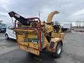 2015 Vermeer Corporation BC1200XL brush chipper with a yellow body and red safety railing positioned with the chute extended for processing branches and foliage