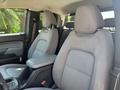 The interior of a 2017 Chevrolet Colorado showing two front seats with gray fabric upholstery and a central armrest between them
