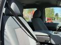 Interior view of a 2015 Ford F-550 showing the front seats and center console with a seatbelt secured in place