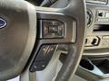Close-up of the steering wheel of a 2021 Ford Econoline featuring audio control buttons and a textured grip