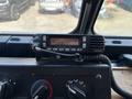 A Kenwood radio mounted in a vehicle's dashboard with buttons and a display showing 21-DISP-BBY