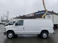 A white 2011 Ford Econoline van with a raised bucket lift attached to the roof