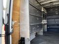 Interior view of a 2010 Mercedes-Benz Sprinter showing metallic shelving units and storage compartments inside the cargo area