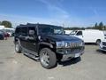 A black 2003 Hummer H2 parked with chrome wheels and side steps showcasing its large body and distinctive design
