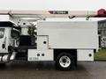 A white 2020 International MV607 utility truck with a mounted Terex aerial lift on the top and a storage compartment on the side