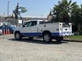 A 2017 Chevrolet Colorado in white with blue accents features a truck bed with storage compartments and a tool rack mounted on its rear