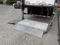 A 2019 Ford F-750 with a lowered hydraulic lift gate at the rear ready for loading or unloading cargo