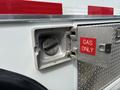 The fuel door of a 1994 GMC Vandura 3500 with a metal cover and a label that reads GAS ONLY