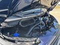 The engine compartment of a 2016 Ford Transit 150 showcasing the engine with various components such as hoses wires and the air intake system