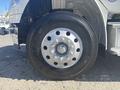 A close-up view of a tire mounted on a 2022 Freightliner M2 106 truck highlighting the wheel's silver rim and black tire with prominent tread details