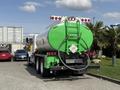 A green 1996 Kenworth T800 tanker truck with a rounded tank and a hose attached at the rear