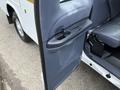 A 2001 Ford F-350 with a partially open driver's side door showing the interior door panel and handle