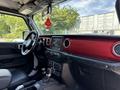 Interior view of a 2021 Jeep Wrangler showcasing a red dashboard a touchscreen display and gear shifter