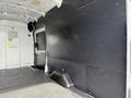A 2021 Ford Transit van interior with a black wall panel and a grey floor featuring a molded plastic component at the base of the wall