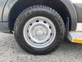 Close-up of a wheel on a 2018 Ford Transit-350 featuring a silver rim with five circular openings and a radial tire with a tread pattern designed for traction