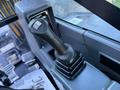 A close-up of the joystick control in a 2023 Sany SY35U excavator's cabin with a black grip and multiple switches visible