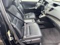 Interior of a 2014 Honda CR-V featuring leather seats with seat belts and a console between the front seats