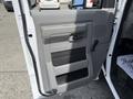 The interior door of a 2018 Ford E-450 featuring a gray panel with a handle and controls for windows and locks