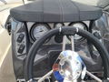 The image shows the steering wheel and dashboard of a 2013 Larson 238 with two round gauges and control buttons on the left side