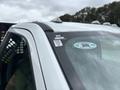 A 2023 Ford F-450 Super Duty with a close-up view of the driver's side window and door frame showing vehicle identification labels and a sticker
