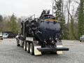 A 2018 Kenworth T800 truck with a large black tanker attachment equipped with various pipes and valves on the rear side