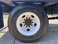 Close-up of a wheel from a 2004 Ford F-750 featuring a white rim and a heavy-duty tire with visible treads and markings