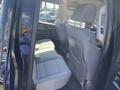 Interior view of a 2014 GMC Sierra 1500 showing rear seats in light gray upholstery with a floor mat and seatbelts visible