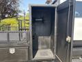 A 2005 GMC C7500 Topkick with an open storage compartment featuring a mounted spool and a drainage grate on the floor