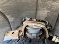 A close-up view of the suspension system and axle components of a 2014 GMC Sierra 1500 showing rusted parts and a tire in the frame