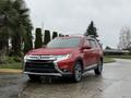 A red 2016 Mitsubishi Outlander is parked with its front facing the camera showcasing its sleek design and chrome accents on the grille