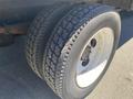 A close-up view of a set of two large, worn tires mounted on a white rim designed for a 2014 International TerraStar truck