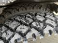 Close-up of a rugged tire from a 2013 International 4300 showcasing deep treads and a worn surface
