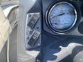 Control panel of a 2013 Larson 238 featuring switches for various functions and a round RPM gauge indicating engine speed