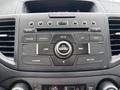 The dashboard controls of a 2014 Honda CR-V featuring buttons for air conditioning radio and phone functions