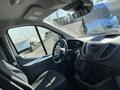 Interior view of a 2017 Ford Transit with a focus on the driver's side featuring a steering wheel and dashboard controls
