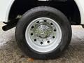 Close-up of a silver rim and tire from a 2024 RAM 5500 showcasing a shiny wheel with a central logo and a thick tread pattern