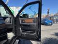 2015 RAM 1500 driver side door open showcasing the interior panel with wood trim and controls for windows and locks