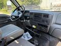Interior of a 2008 Ford F-750 showing the dashboard steering wheel and gear shift with gray fabric seats and controls visible