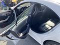 A 2014 Mercedes-Benz CLA-Class with an open door revealing a black leather interior and dashboard with various controls and features